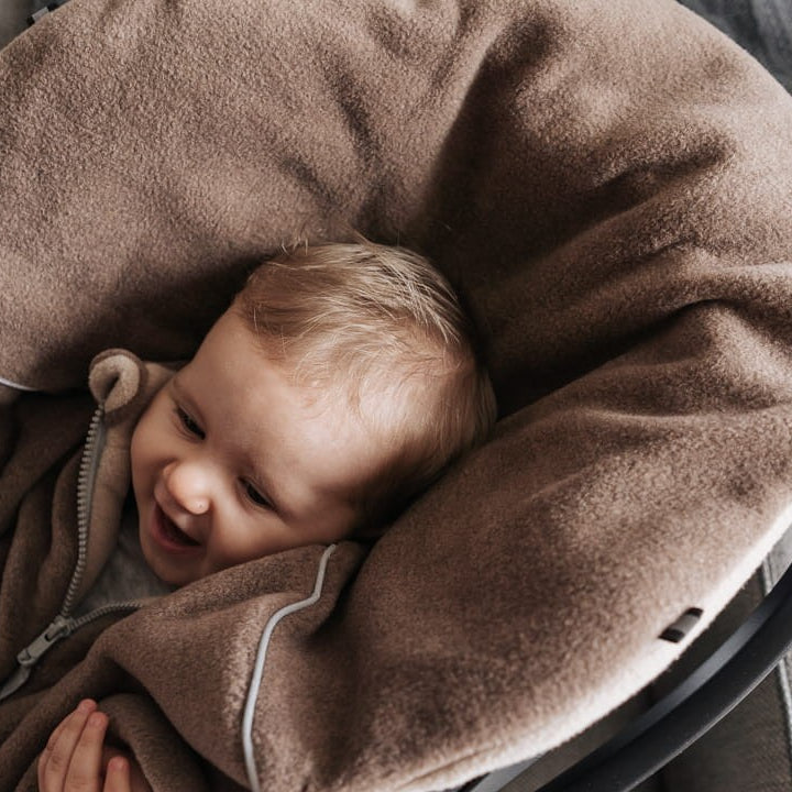 Lapsi istumassa ruskeassa Brave Bear -turvaistuinviitassa turvaistuimessa.