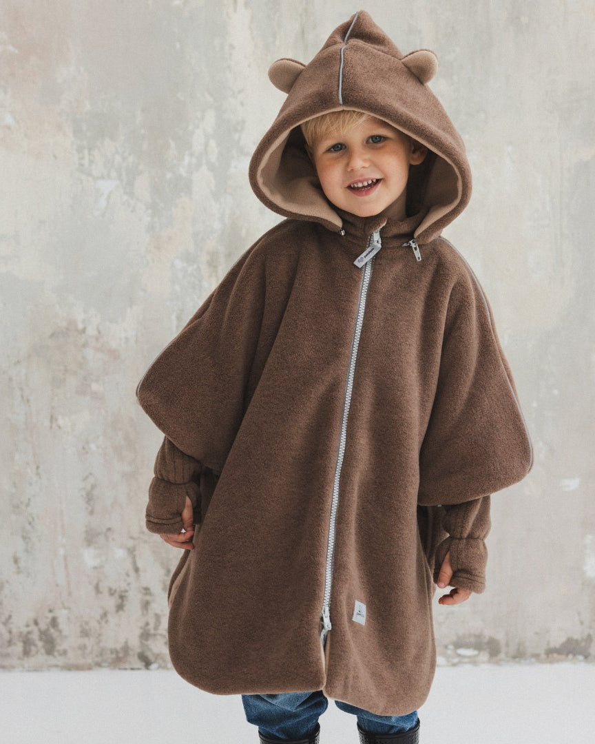 Brave Bear -autoponcho lapsella, huppu päässä, pehmeä kangas näkyvissä.