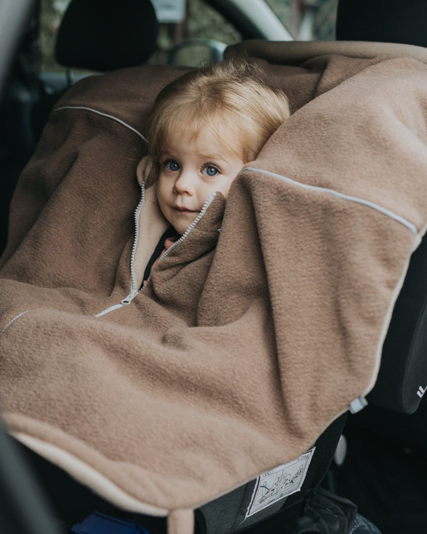 Lapsi istumassa ruskeassa Brave Bear -turvaistuinviitassa autossa.