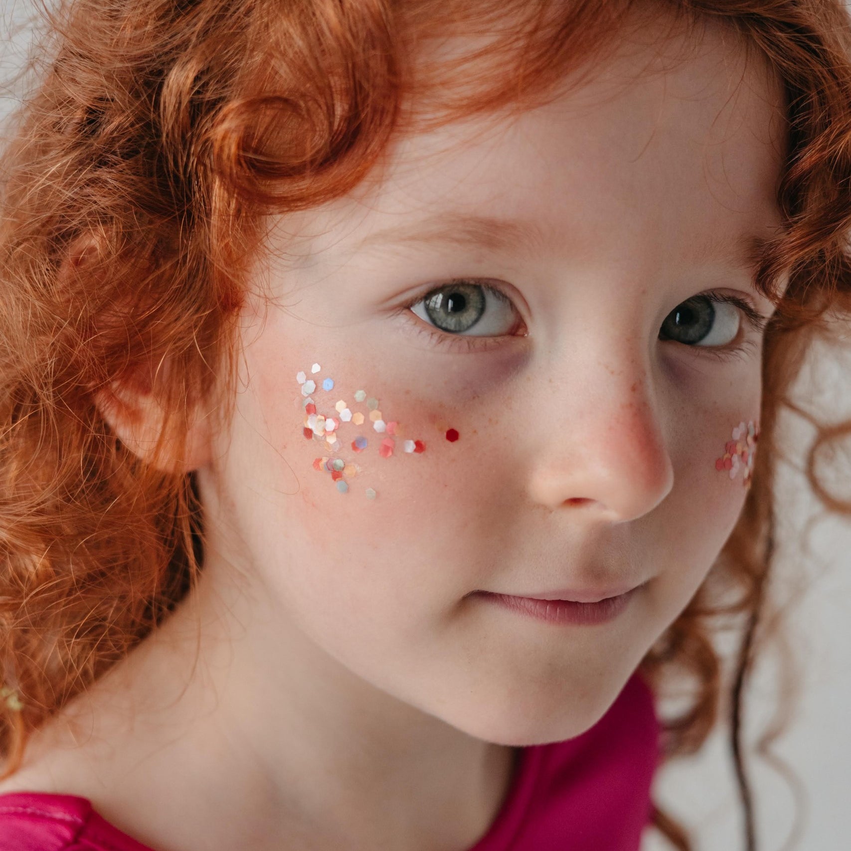 Rainbow Star Dust ekoglitter lasipurkissa, kimalle levitettynä lapsen kasvoille