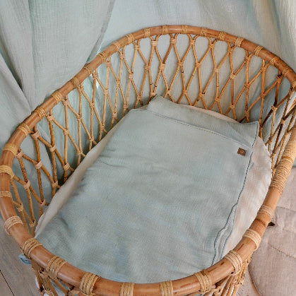 Musliininen vauvan peitto ja tyynysetti mintun sävyssä vauvan rottinkisessa vauvan sängyssä