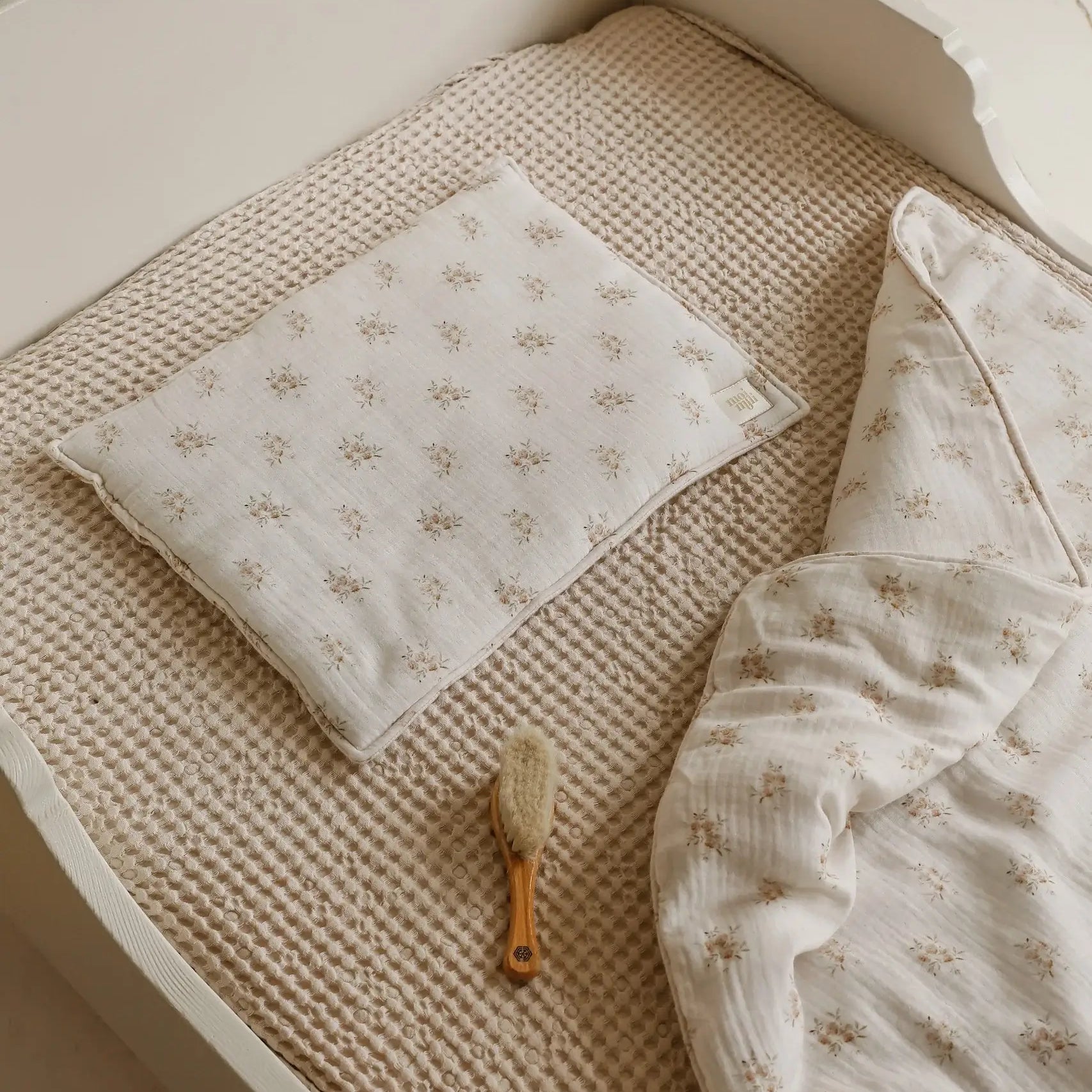 Musliininen vauvan peitto ja tyynysetti Boho Flowers -kuosilla vauvan sängyssä