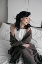 Naisella on hartioillaan alpakanvillasta tehty klassinen torkkupeitto