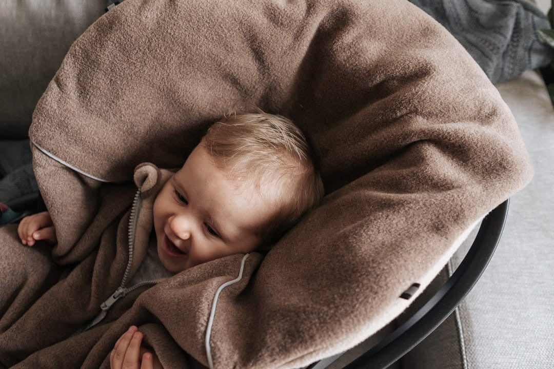 Lapsi istumassa ruskeassa Brave Bear -turvaistuinviitassa turvaistuimessa.